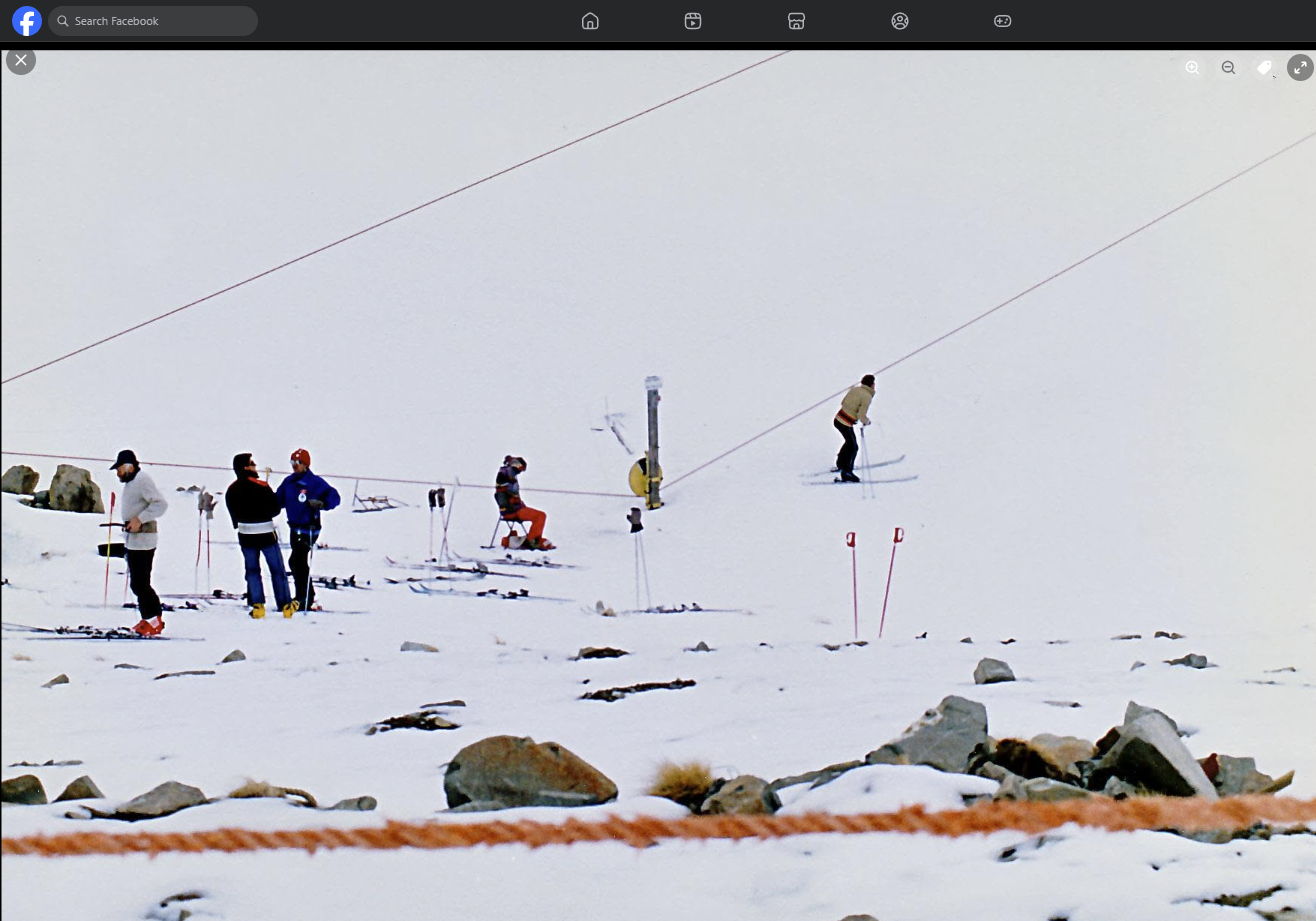 Members queuing for the rope tow, with one skier getting on partway up the slope