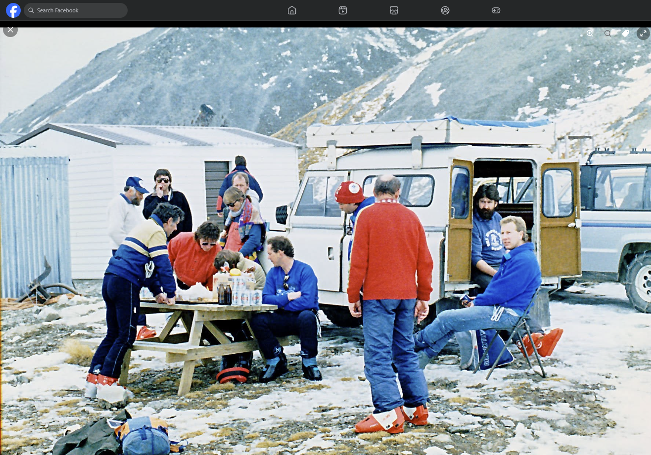 A group of club members having lunch on the field beside a Land Rover