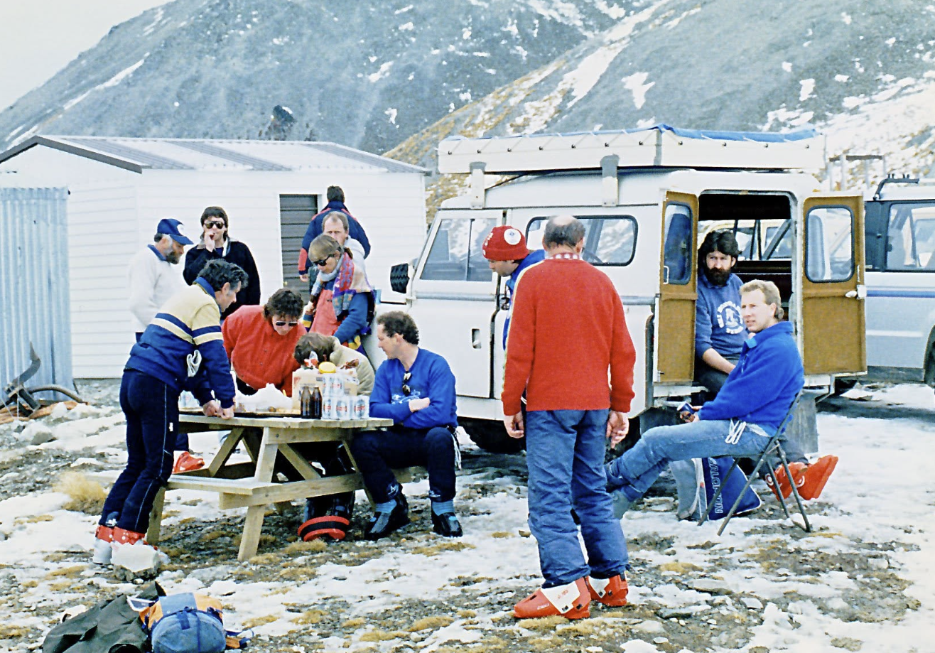 A group of club members having lunch on the field beside a Land Rover
